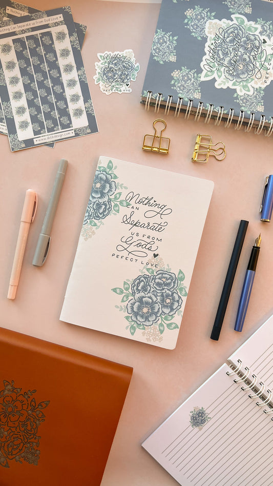 Cream Christian prayer journal notebook featuring a blue floral design & Hand-lettering inspired by Romans 8:38-39 on the cover