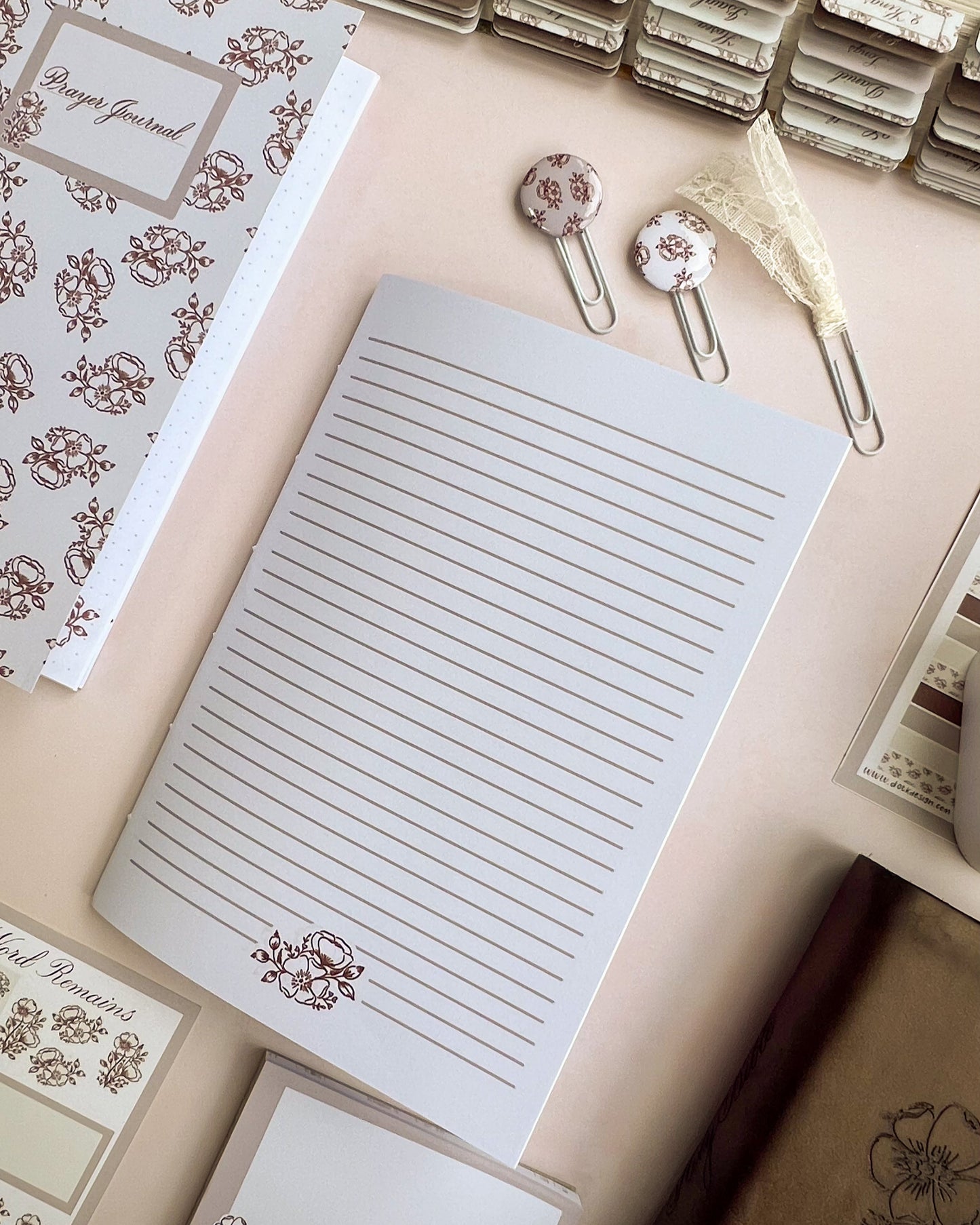 Open Christian prayer journal notebook featuring lined pages and Sepia toned floral accents at the base of each page.