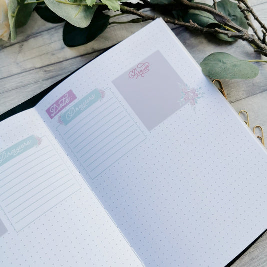 Open Christian prayer journal notebook featuring prompted sections and pink florals