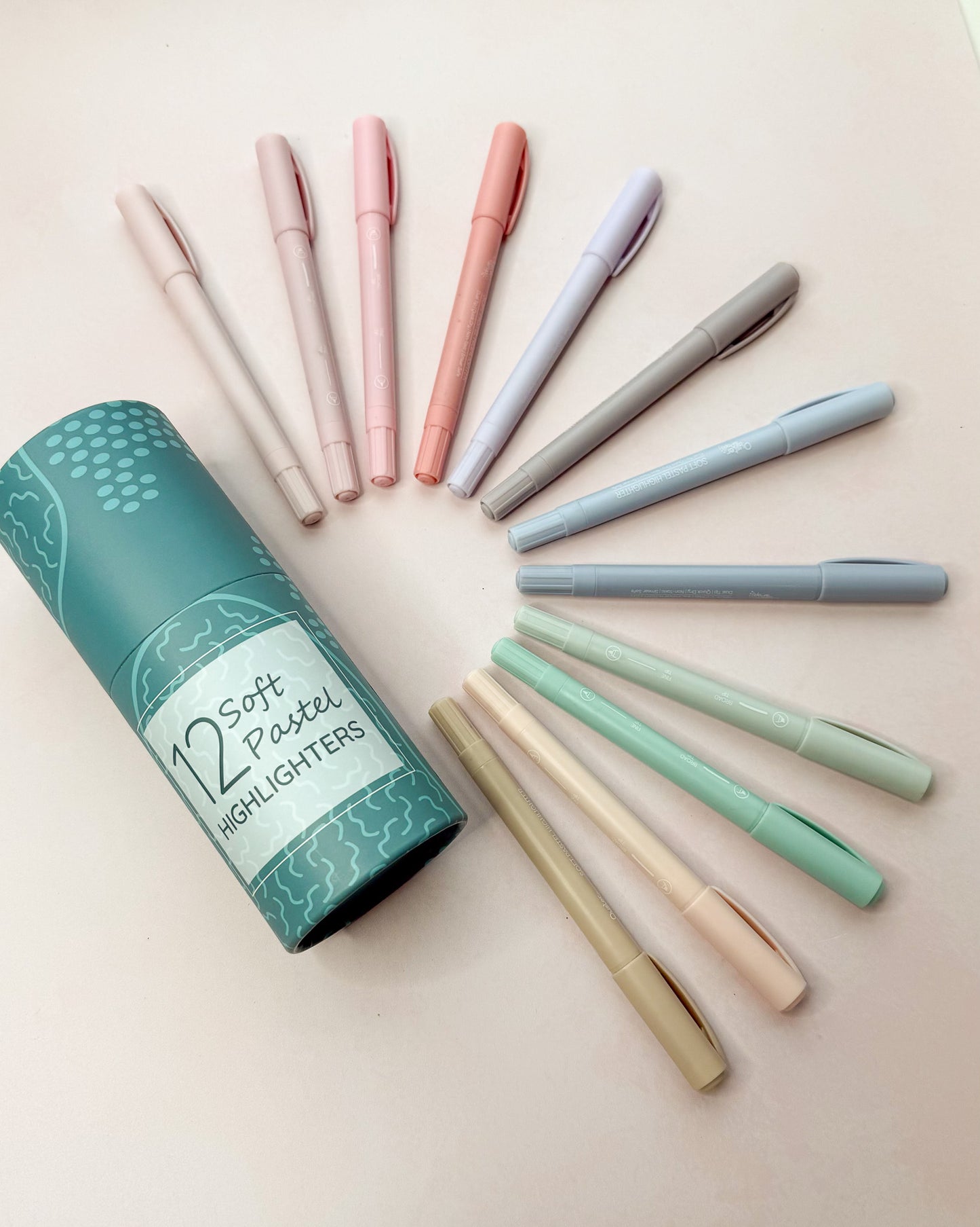 Set of pastel highlighters arranged beside their storage tube
