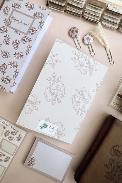 The back cover of a Sepia toned Christian prayer journal notebook featuring a floral design & Hand-lettering inspired by Isaiah 40:8 on the cover.