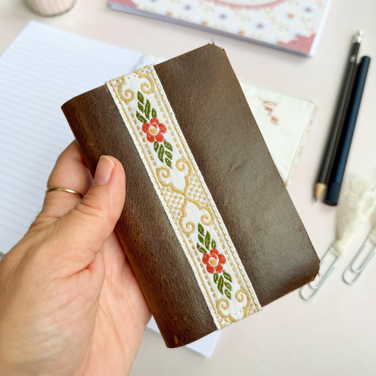 Pocket Bible with brown leather cover and woven floral trim