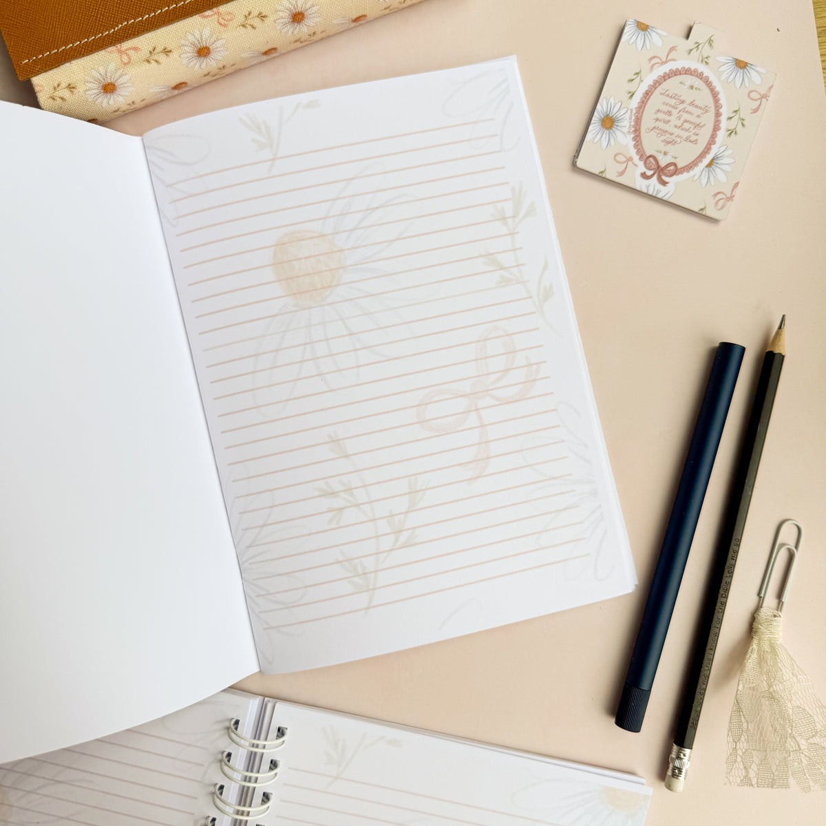Wirebound notebook with daisies and bows, with a hand lettered excerpt from 1 Peter 3:3-4